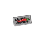 A rectangular resin-coated label featuring a red chilli and the text "chilli beans" in black on a silver background.
