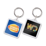 A square key ring featuring the Bandai Namco logo on one side and the Wonderworld Designs logo on the other side.