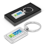 A rectangular metal key ring featuring a customizable design, presented in a sleek black box.