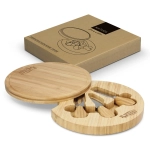 A round bamboo cheese board with three cheese knives, displayed in a cardboard box with a logo.