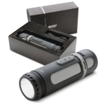 A Swiss Peak 4-in-1 speaker in black, displayed with its box and charging cable, featuring various buttons on the device.