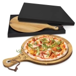 A wooden serving board with a handle, featuring a pizza topped with various ingredients. Comes in a black box.