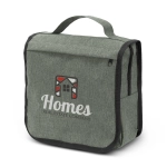 A green toiletry bag with a fold-over flap, featuring a logo on the front and side zippered pockets.