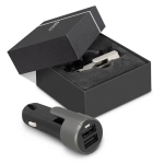 A black and grey USB car charger is displayed next to its box with a foam insert, featuring a logo.