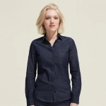 A women's button-up denim shirt in dark blue with a pocket and a branded logo.