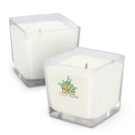 A square, white scented candle in a clear glass container, featuring a logo design. Two candles are shown.