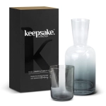 A glass carafe and tumbler set in grey, packaged in a black box with a logo.