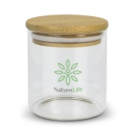 A small round glass storage canister with a bamboo lid and a green logo on the front.