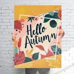 A vibrant sign featuring colourful autumn leaves and flowers with the text "Hello Autumn." Holds a logo.
