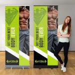 A premium pull-up banner featuring a fitness theme, with a green and black design and a logo at the bottom.