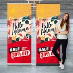 A stylish pull-up banner with autumn-themed designs, featuring floral patterns in red, yellow, and green, alongside a model standing next to it.
