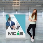 A wide pull-up banner in turquoise and grey featuring an image of a handshake, alongside a person standing next to it.