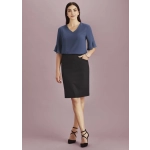 A model wearing a women's pencil skirt in black paired with a blue top, featuring a pocket and stylish heels.