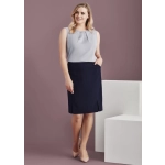 A woman wearing a light grey top and a navy straight skirt with front pleat details, posing against a neutral background.