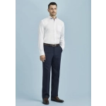 A man wearing a white shirt and navy blue flat front pants, standing against a light blue background.