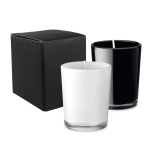 A set of two glass candles, one white and one black, packaged in a black box.