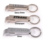 A drink bottle opener and keytag in three colors: silver, champagne, and one with an epoxy dome. Features branding.