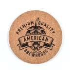 A round cork coaster featuring a black design with bold text and a logo, showcasing a rustic, natural look.