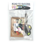 A promotional office pack featuring a notepad, a pen, and assorted colored candies, all packaged in a clear bag.