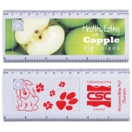 A tile ruler puzzle in white with colorful apple and dog graphics. Features a measuring scale along the edges.