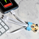 A Custom Topper PVC Cable featuring a dog design, with multiple charging connectors plugged into a smartphone.