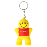 A yellow stress keyring shaped like a smiling little man, featuring a red shirt and attached to a metal keyring.