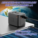 A black travel adaptor with multiple ports, featuring advanced technology and a compact design, resting on a laptop.