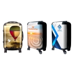 Three wheeled carry-on suitcases featuring colourful designs, including a hot air balloon, sunset, and abstract patterns.