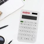 A white calculator with a logo, displaying numbers and various function keys, on a desk with a laptop and stationery.