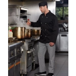 A chef in a black long sleeve jacket stands in a kitchen, stirring a pot, with striped pants and a black hat.