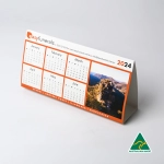 A desk calendar for 2024 with a scenic image, featuring an orange and white design, and a logo.