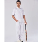 A model wearing white men's cricket pants, paired with a matching polo shirt, holding a cricket bat.