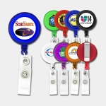 A selection of round badge holders in various colours, each with a logo, attached to a retractable clip.
