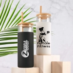 A set of two glass tumblers with bamboo lids, one black and one white, featuring logos and designs.
