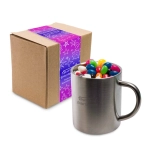 A Java mug filled with assorted color mini jelly beans, placed next to a packaged box.