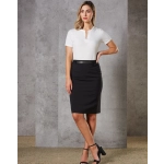 A woman poses in a fitted black wool stretch pencil skirt with a white top against a textured grey background.
