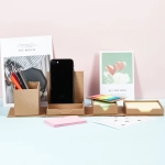 A desk organiser featuring compartments for sticky notes, pens, and a phone holder in a natural cardboard colour.