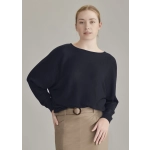 A black batwing sweater top worn by a model, paired with a beige skirt, showcasing relaxed fit and casual style.