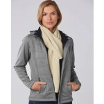 A woman wearing a grey jacket and a cream cable knit scarf, showcasing the scarf's texture and style.