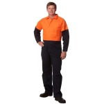 A man stands wearing a two-tone high-visibility cotton drill coverall in orange and navy blue. The coverall features pockets and has a logo.