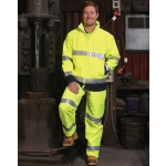 A bright yellow two-tone safety jacket with reflective strips, worn by a person in a workshop setting.