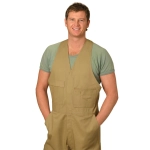 Men's cotton drill action back overall in beige, featuring pockets and worn over a green shirt. Model is smiling.