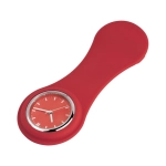 A red silicone watch with a circular watch face and silver accents. It features a simple design and a logo.