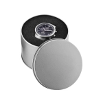 A round silver watch case containing a dark watch, set against a textured black background.