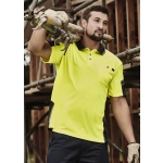 A man in a bright yellow short sleeve polo with black accents, carrying scaffolding pipes at a construction site.