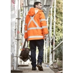 A waterproof orange jacket with reflective strips, worn by a man carrying a tool bag, against a construction backdrop.