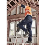 Men's cargo pant in navy, worn by a man on a ladder, working in a partially constructed building. The pants have pockets and a logo.