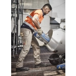 Men&rsquo;s cargo pants in beige, featuring multiple pockets, worn by a worker pouring materials into a mixer.