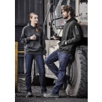 A pair of people wearing black hoodies and blue stretch denim work jeans, standing beside a large vehicle tire.