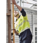 A man wearing a high visibility segmented tape long sleeve shirt in yellow and navy, working on a construction site.